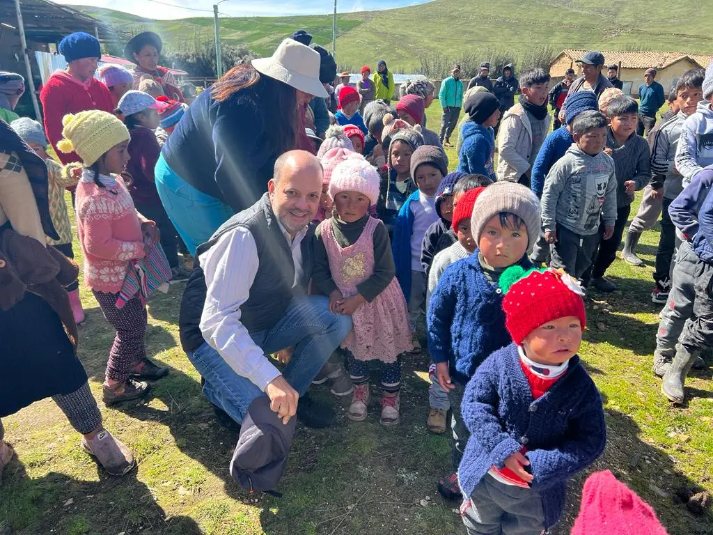 El equipo de Sonqo junto a niños de la comunidad, entregando casacas en persona